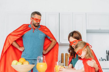 baba kalçaelleri ile ayakta iken mutfakta kahvaltı yaparken süper kahraman kostümleri aile