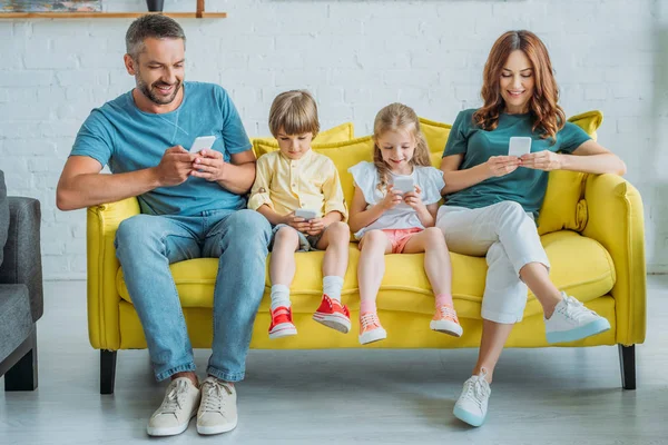 Happy Mother Father Children Sitting Sofa Using Smartphones — Stock Photo, Image