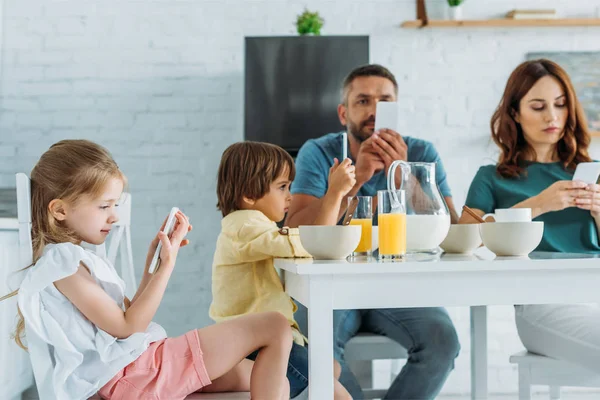 Famille Utilisant Des Smartphones Tout Étant Assis Dans Cuisine Près — Photo