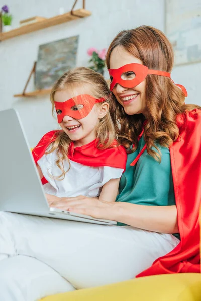 Cheerful Mom Daughter Costumes Superheroes Using Laptop Home — Stock Photo, Image