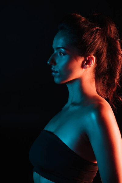 вид сбоку привлекательной молодой женщины, изолированной на черном
 