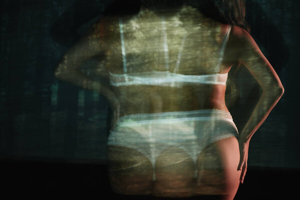 длинная экспозиция сексуальной девушки, стоящей в кружеве белое белье рядом с деревьями
 