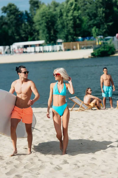 Handsome Young Man Holding Surfboard While Walking Attractive Woman Swimsuit — Stock Photo, Image