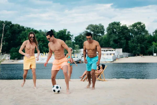 Красиві Мультикультурні Чоловіки Грають Футбол Пляжі Біля Молодих Жінок — стокове фото