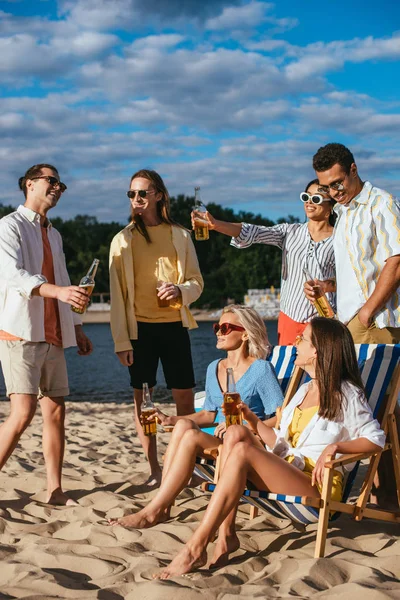 Allegri Amici Multiculturali Che Parlano Mentre Bevono Birra Sulla Spiaggia — Foto Stock