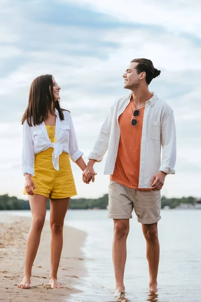 Vidám Fiatal Pár Kezét Nézi Egymást Miközben Séta Strandon — Stock Fotó