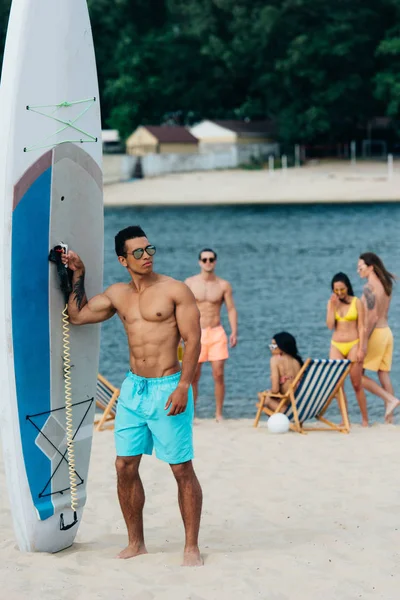 Handsome Mixed Race Man Looking Camera While Standing Surfboard Beach — Stock Photo, Image