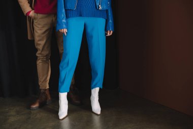 elbiseli şık erkeğin kısmi görünümü ve perdenin yanında duran deri ceketli kadın