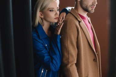 siyah perde yakınında sonbahar giysileri şık genç kadın ve erkek kırpılmış görünümü