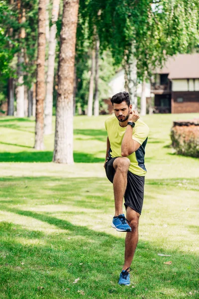 緑の芝生で運動するハンサムな若いスポーツマン — ストック写真
