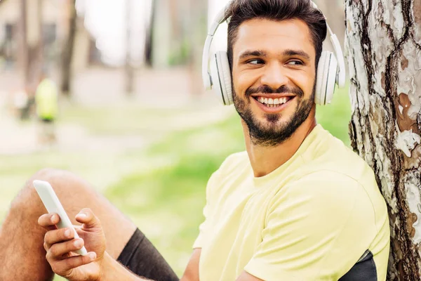 Glad Skäggiga Man Lyssnar Musik Och Använder Smartphone Parken — Stockfoto