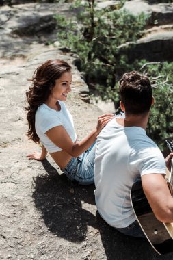 neşeli kadın yakınında akustik gitar çalan sakallı adamın havai görünümü 