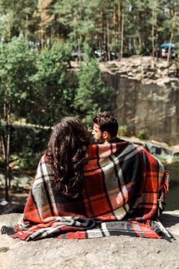 ormanda ekose battaniye sarılmış kız ve adam arka görünümü 