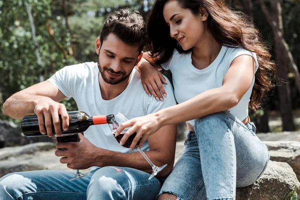 Bell Uomo Versando Vino Rosso Dalla Bottiglia Vicino Donna Attraente — Foto Stock