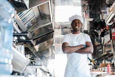 yemek kamyonunda çapraz kolları ile ayakta mutlu Afrikalı Amerikalı şef seçici odak 