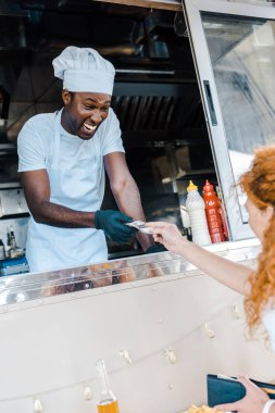redhead kız seçici odak gıda kamyon mutlu afrikalı Amerikalı adam nakit veren 