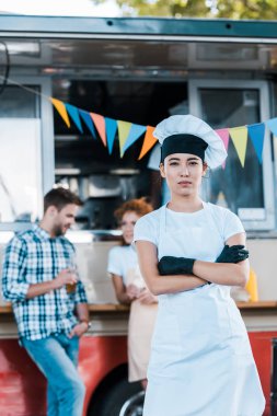 asya şef seçici odak gıda kamyon ve müşterilerinin yakınında çapraz kolları ile ayakta 