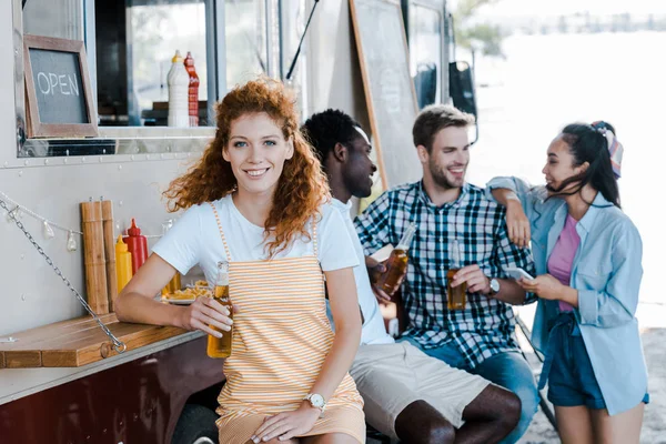 Selective Focus Happy Redhead Girl Holding Bottle Beer Friends Food — Stock Photo, Image