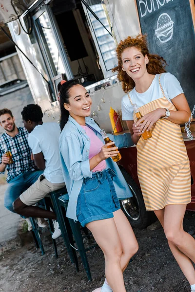 Foco Seletivo Mulheres Felizes Segurando Garrafas Com Cerveja Perto Homens — Fotografia de Stock
