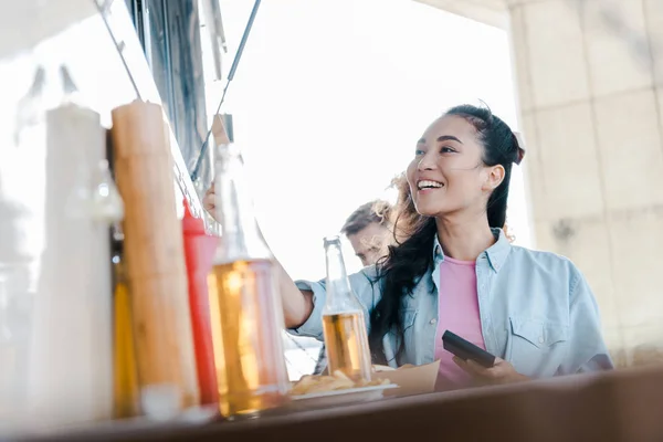 Foco Seletivo Menina Asiática Feliz Sorrindo Perto Garrafas Com Cerveja — Fotografia de Stock
