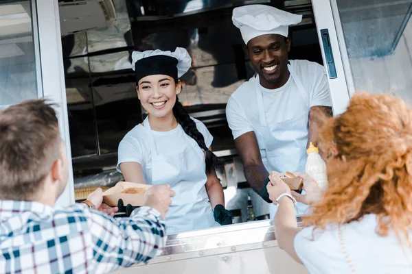 Selektivní Zaměření Šťastných Multikulturních Šéfkuchařů Kteří Dávají Karton Desek Potravinami — Stock fotografie