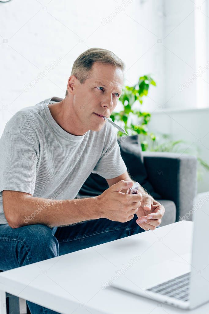 handsome man in t-shirt smoking blunt with medical cannabis