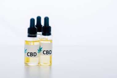 beyaz arka plan üzerinde cbd harfleri ile şişelerde esrar yağı 