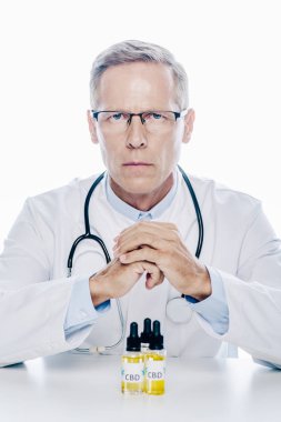 beyaz üzerinde izole masada cbd ile beyaz ceket yakışıklı doktor 