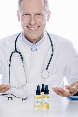 beyaz üzerinde izole masada cbd ile beyaz ceket yakışıklı doktor 