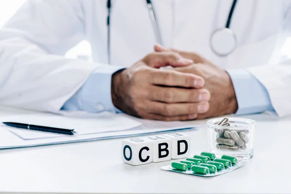 selective focus of cubes with lettering cbd and pills