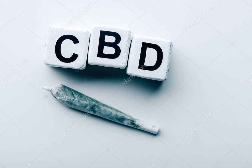 top view of cubes with lettering cbd and blunt on white background 