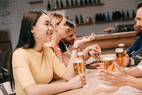 Amigos Multiculturales Felices Hablando Mientras Beben Cerveza Juntos Pub —  Fotos de Stock