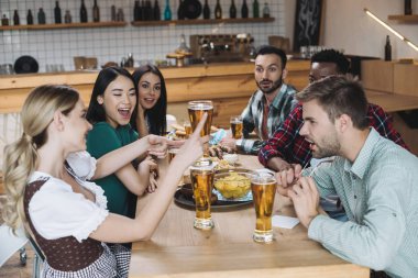 mutlu, genç çok kültürlü arkadaşlar pub birlikte octoberfest kutluyor