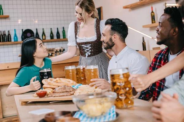 Attractive Waitress Traditional German Costume Serving Beer Multicultural Friends Pub — Stock Photo, Image