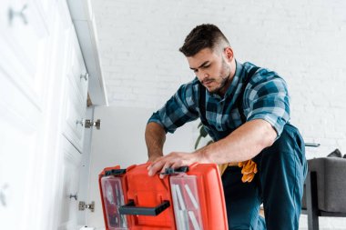 mutfakta açılan alet çantası bakarak yakışıklı handyman seçici odak 