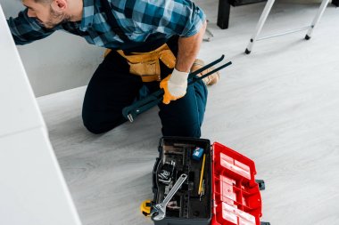 aletleri ile alet çantası yakınında mutfakta çalışan sakallı adam havai görünümü 