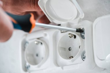 güç prizinin yakınında tornavida tutan teknisyen yakın çekim 