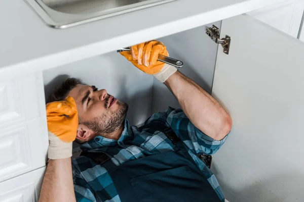 Reparador Barbudo Segurando Chave Ajustável Enquanto Trabalhava Cozinha — Fotografia de Stock