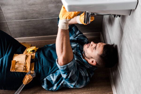 selective focus of repairman fixing water damage in bathroom 