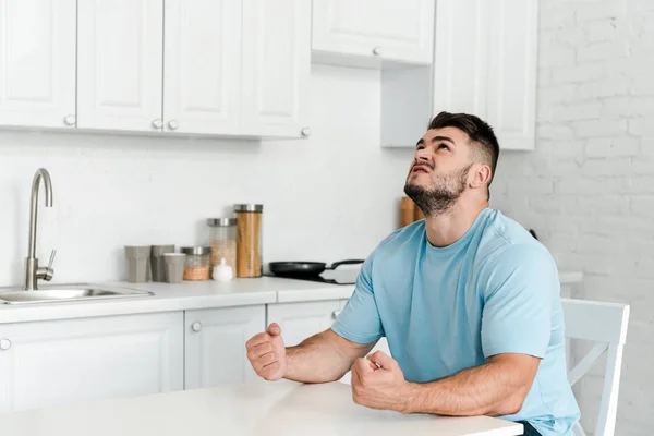 Homem Zangado Gesticulando Enquanto Sentado Perto Mesa Cozinha — Fotografia de Stock