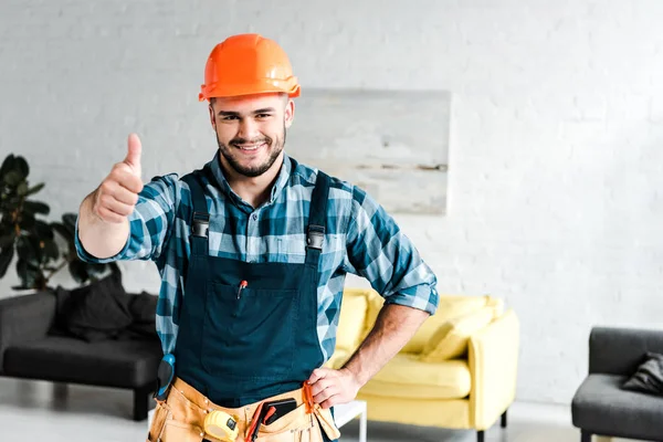 Fröhlicher Arbeiter Mit Schutzhelm Blickt Kamera Und Zeigt Daumen Hoch — Stockfoto