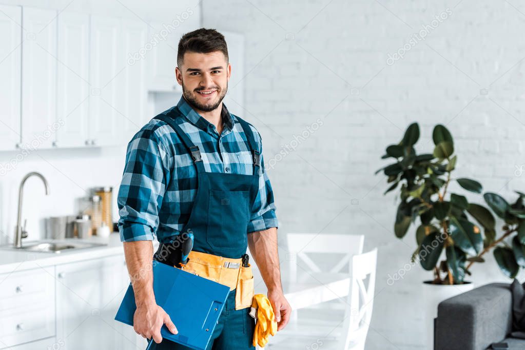 happy bearded workman standing and holding clipboard 