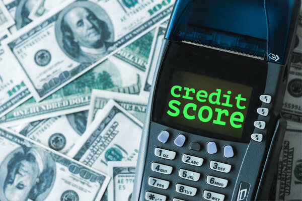 top view of payment terminal with credit score lettering on dollar banknotes 