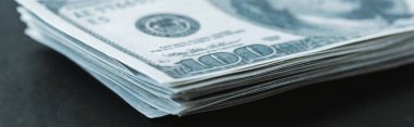 panoramic shot of stack with dollar banknotes on black  clipart