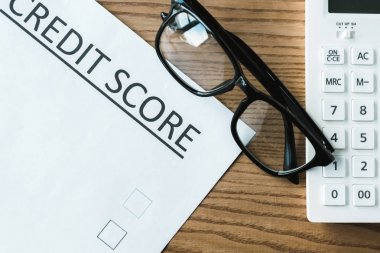 kredi puanı yazı ve hesap makinesi ile kağıt yakınındaki gözlük üst görünümü 