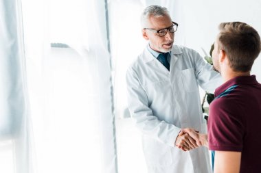 gözlük mutlu doktor klinikte adam ile el sıkışma 