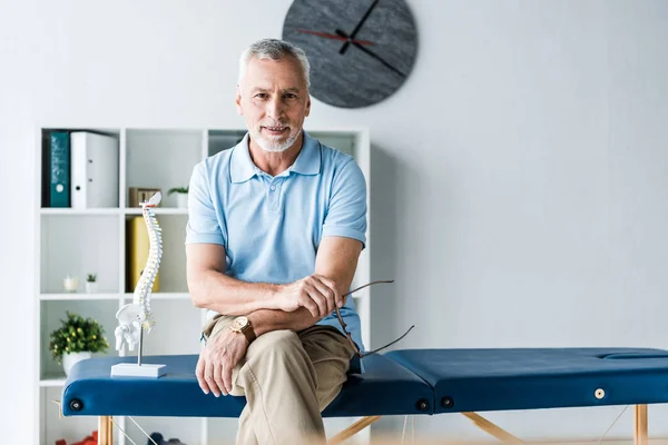 Hombre Alegre Sentado Mesa Masaje Sosteniendo Gafas — Foto de Stock