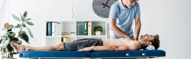 masaj masasında adama masaj yapan sakallı chiropractor panoramik çekim 