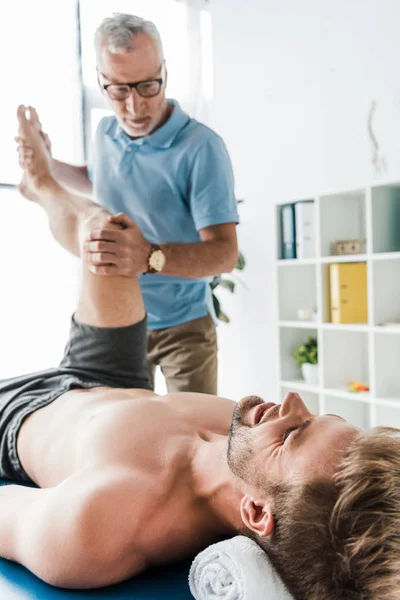 Focalizzazione Selettiva Del Paziente Sdraiato Sul Lettino Massaggio Che Lavora — Foto Stock