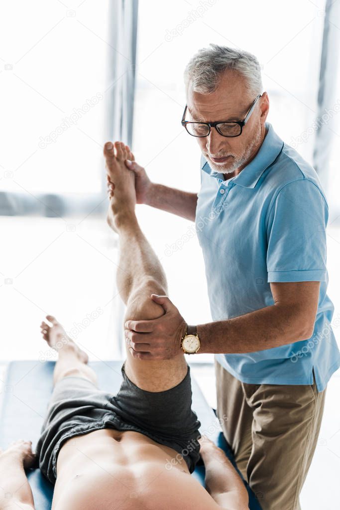 cropped view of patient working out near doctor in glasses 